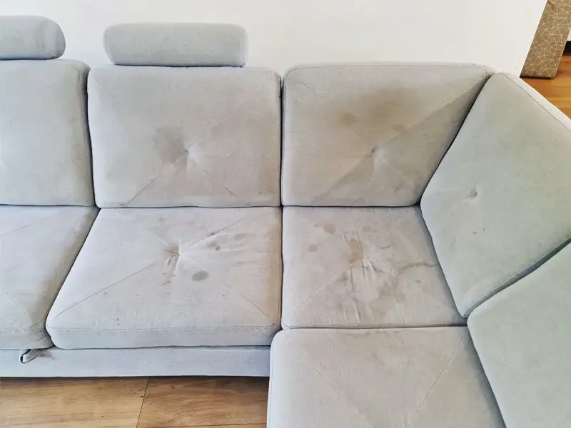 Zdjęcie kanapy z poplamioną tapicerką.